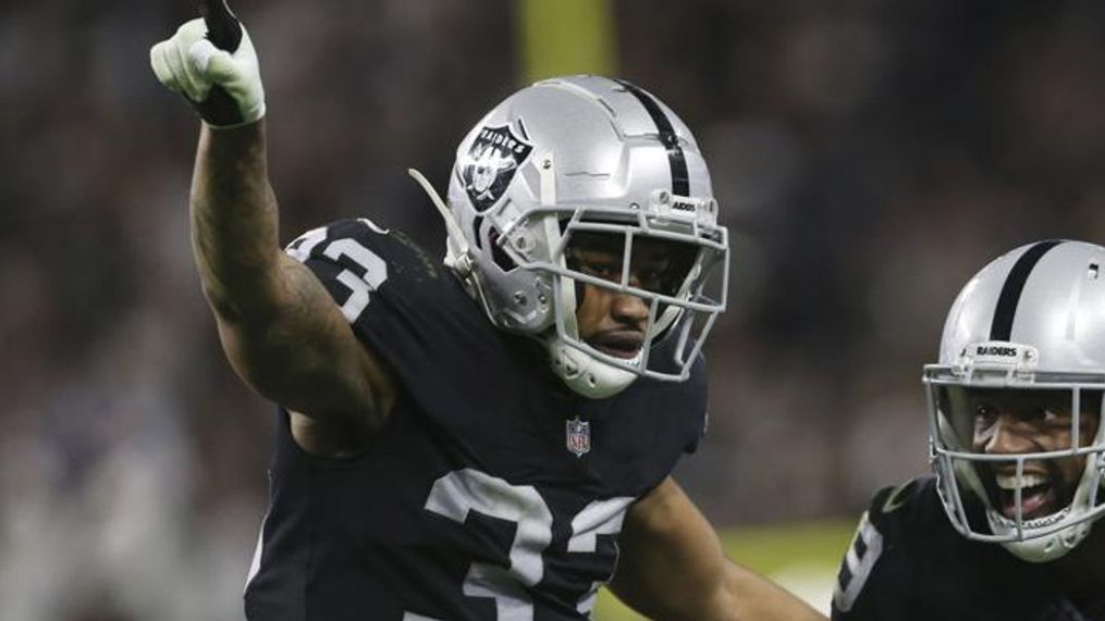 Las Vegas Raiders safety Roderic Teamer (33) celebrates after cornerback Casey Hayward, right, made an interception against the Los Angeles Chargers during the second half of an NFL football game, Sunday, Jan. 9, 2022, in Las Vegas. (AP Photo/Ellen Schmidt)