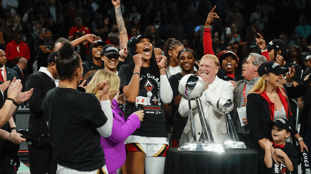 Las Vegas Aces' A'ja Wilson and Mark Davis celebrate with teammates next to the trophy after Game 4 of a WNBA basketball final playoff series against the New York Liberty Wednesday, Oct. 18, 2023, in New York. The Aces won 70-69. (AP Photo/Franklin II)