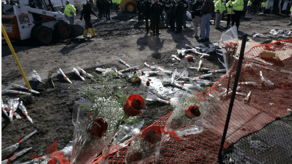 Flowers are left in memorial near the site where workers and investigators clear debris from the scene of the plane crash of Continental Connection Flight 3407 on February 16, 2009 in Clarence, New York. The Bombardier Dash 8 Q400, that crashed on approach to Buffalo Niagara International Airport on February 12, 2009, killed all 49 people on the plane and one on the ground. Today investigators removed the engines of the commuter plane that slammed into a house in suburban Buffalo.  (Photo by David Duprey-Pool/Getty Images)